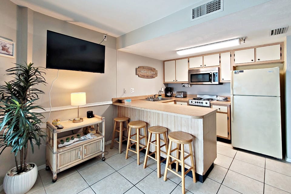 Large kitchen countertop and bar stools for prepping and serving meals.