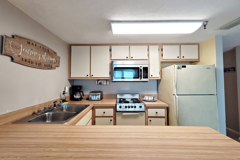 Kitchen features full size frig w/ icemaker, 4 burner stove/oven, dishwasher, microwave, coffee maker, crockpot, dishes, pots/pans, etc.