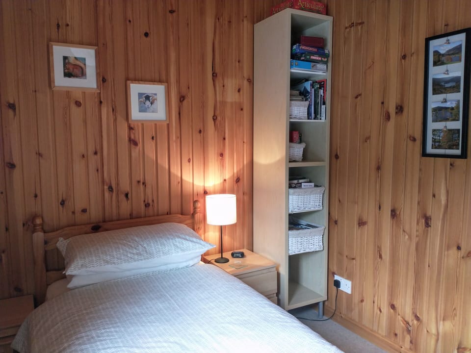 Single bedroom with a selection of games and local maps.