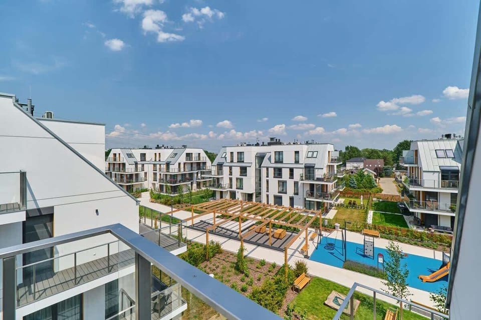 A view from the balcony showing a peaceful neighborhood with modern residential buildings.