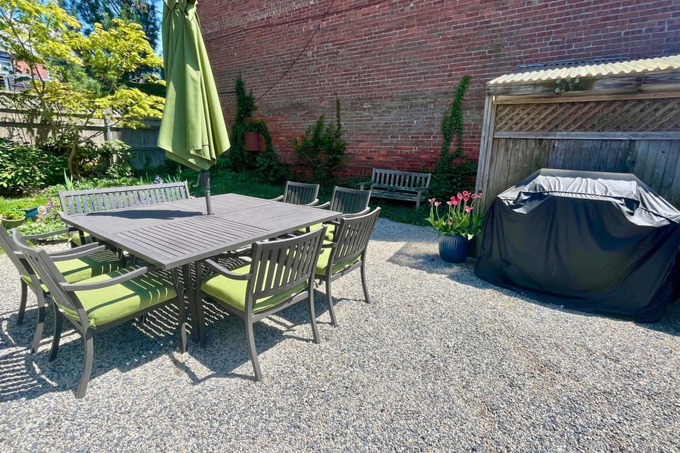 The private backyard features a patio set that seats 8 and a gas grill.