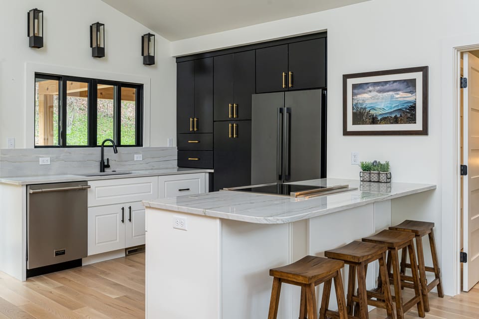 Sleek kitchen with breakfast bar seating for 4, a dishwasher & standard drip coffeemaker.