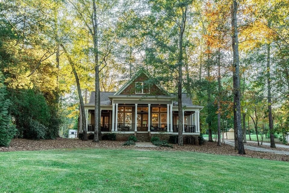 Looking at the house from the lake. Beautiful yard and wrap around porch.