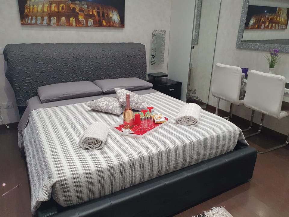 Camera Matrimoniale con Bagno Privato, Frigo, Armadio e Scrivania con Sedie.