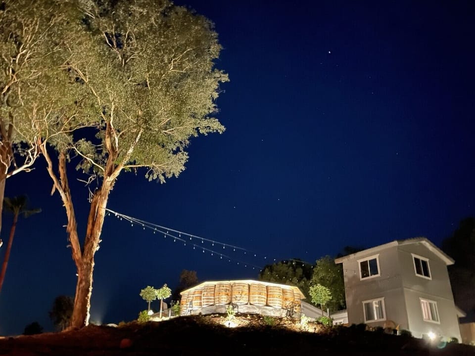 Front of the house at night from the driveway. Lighting for evening activities.