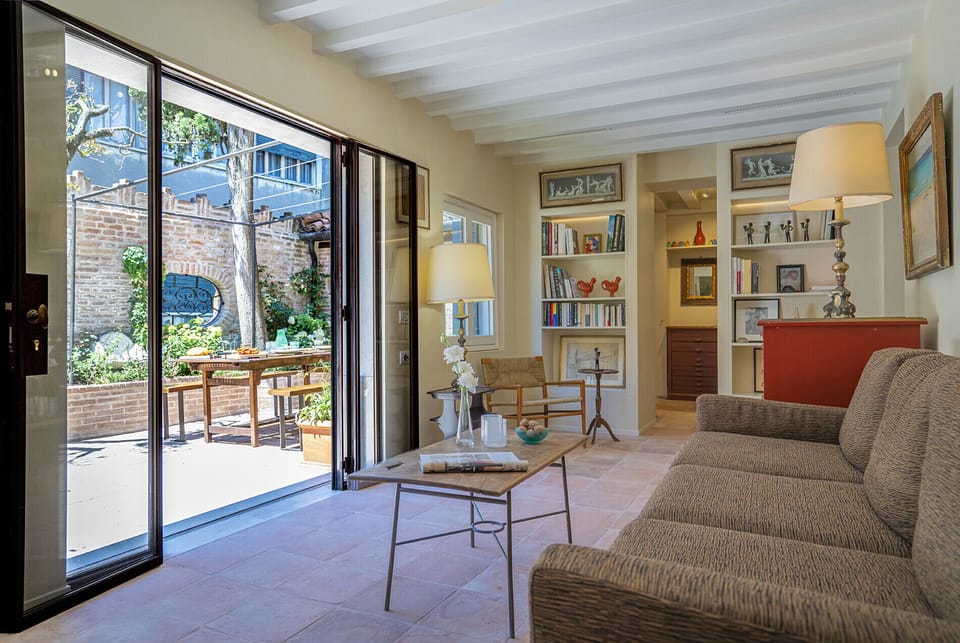 Sitting room furnished with comfy seating and featuring wide bi-fold French windows opening onto your west-facing furnished garden