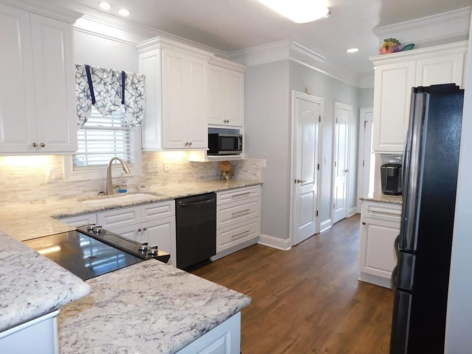 Bright, modern kitchen with spacious granite countertops and hardwood floors