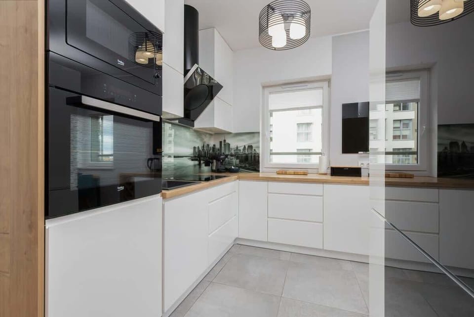 A stylish kitchenette with white cabinets, wooden accents, and a functional island. Perfect for cooking while staying connected to the living area.