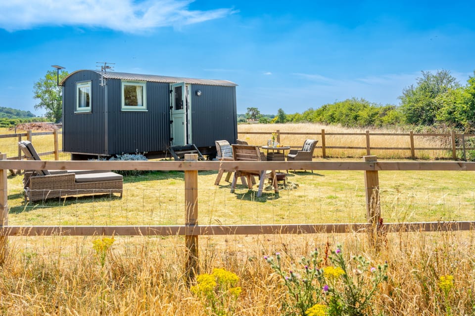 There is a wire running around the wooden fence that surrounds the hut
