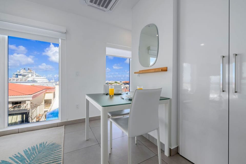 A modern fitness center spans floor-to-ceiling windows overlooking the sparkling sea, where treadmills, bikes, and weights await your waterfront workout.
