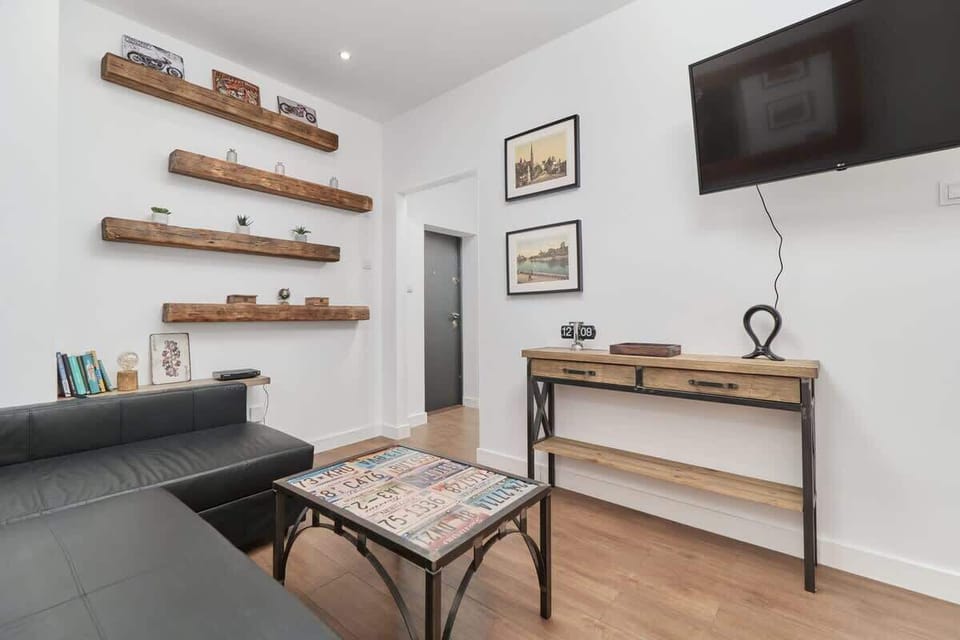 The living area features a sleek coffee table and a flat-screen television.