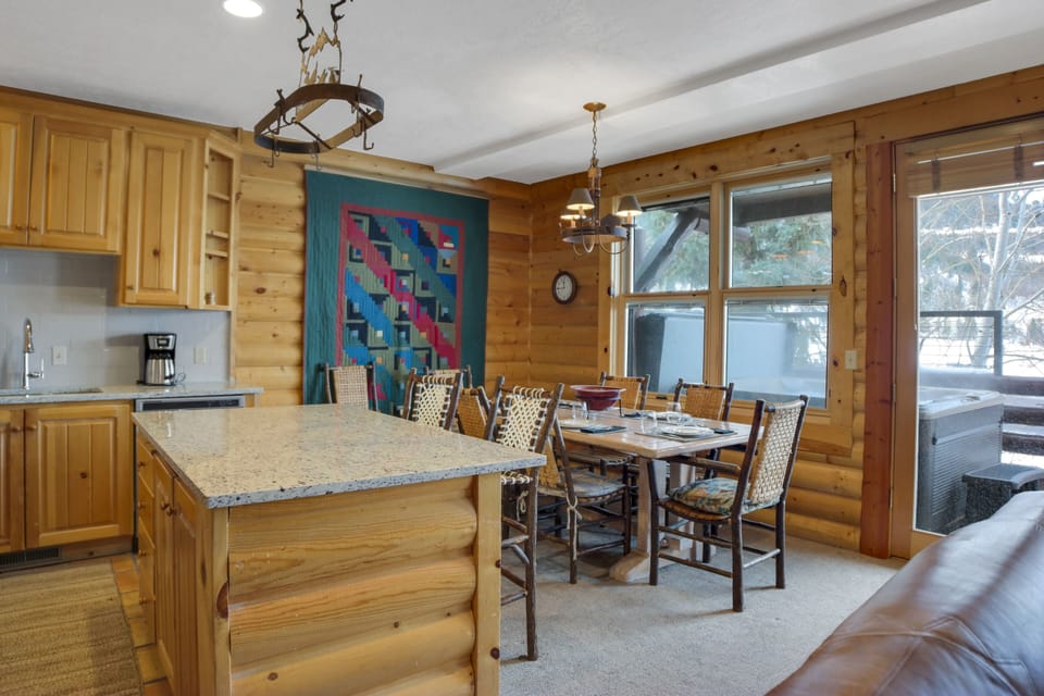 The kitchen and dining area with seating for two at the island and seating for 6 guests at the dining table.