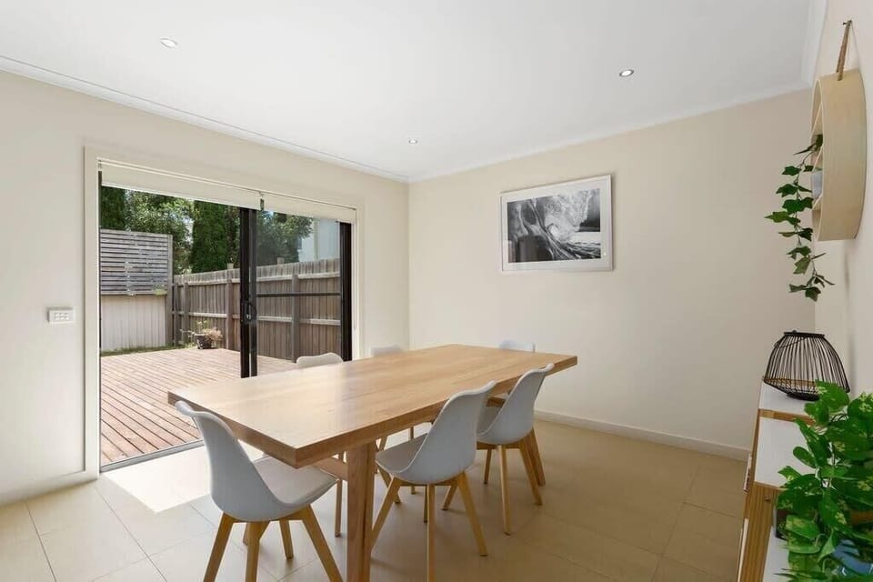 The 6-seater dining table flows directly out to a timber deck & fully fenced outdoor lawn.