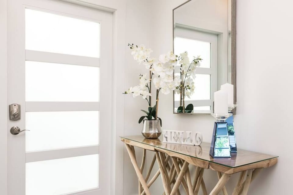 Entryway with a modern glass-top console table and decorative accents.