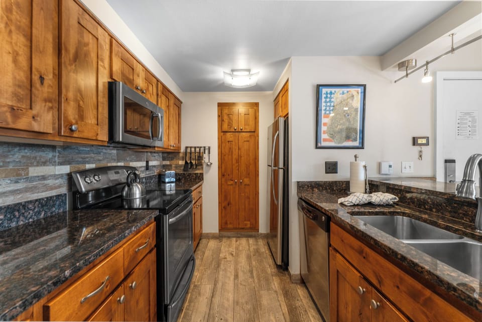 Updated full size kitchen with granite countertops, stainless steel appliances, and breakfast bar for additional seating