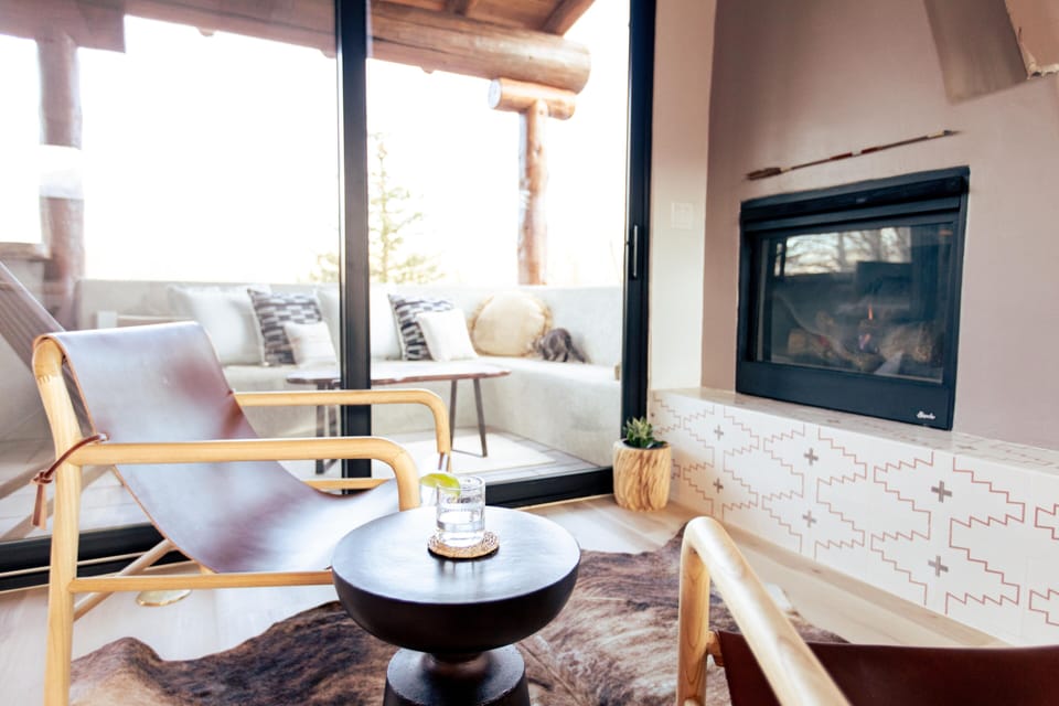 Seating area with gas fireplace and floor to ceiling glass sliding doors.