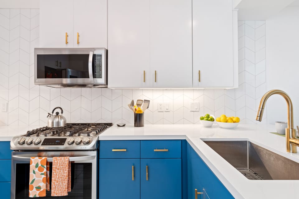 The chef's kitchen is chic with blue lower cabinets and white upper cabinets.