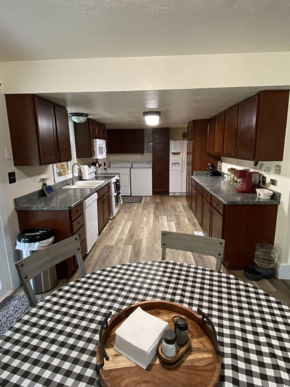Dining room table with washer/dryer and fridge in background