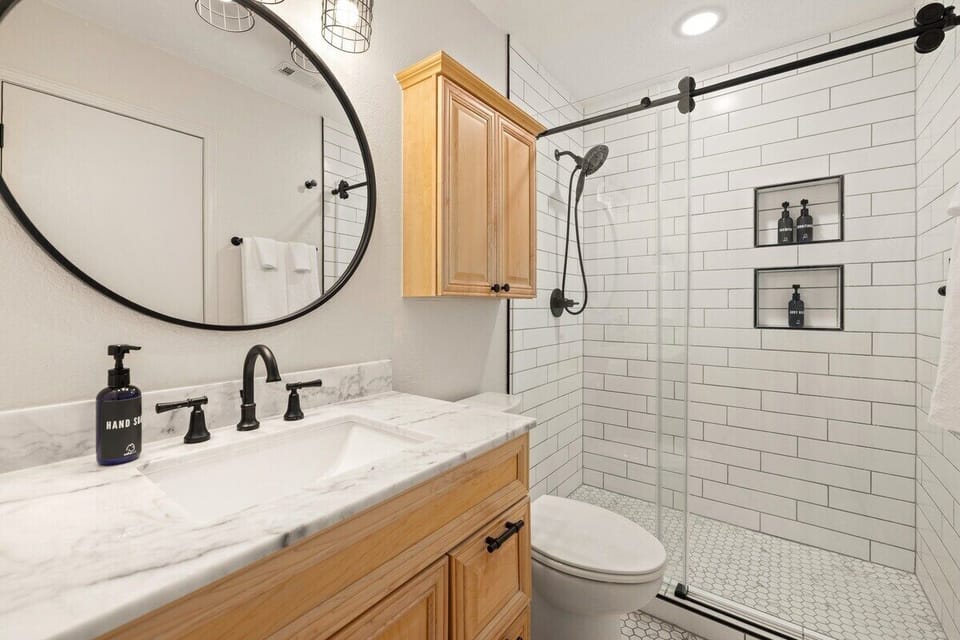 NEWLY RENOVATED! The King bedroom's en suite bathroom features a spacious walk-in shower + fully stocked with toiletries.