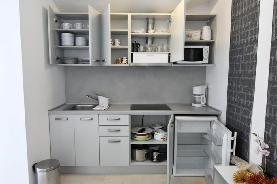 The kitchen equipped with refrigerator, microwave oven, coffee machine