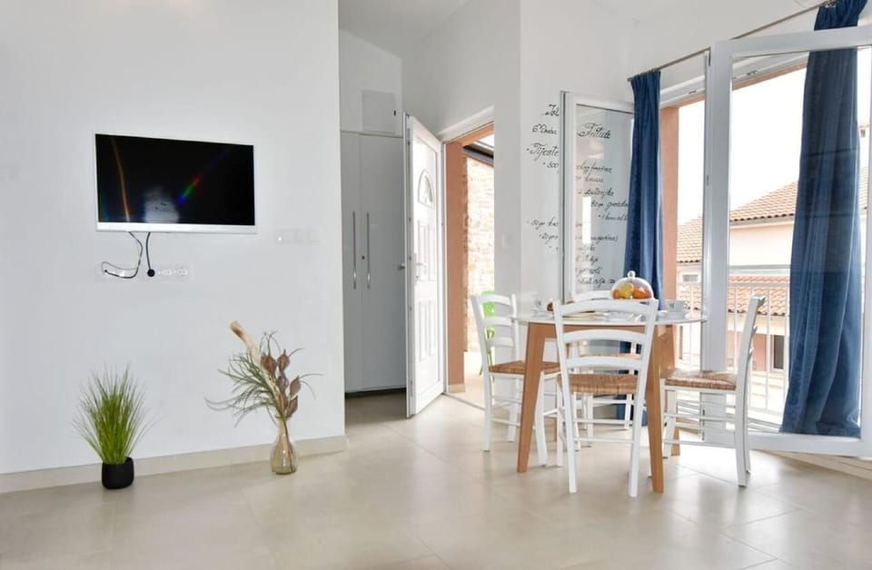 The living area with flat screen satellite TV, dining table with chairs