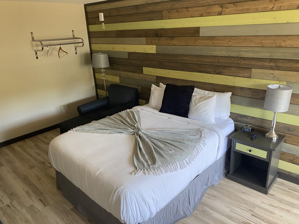 Queen bed and soft chair and stool to put your feet up in this cozy room
