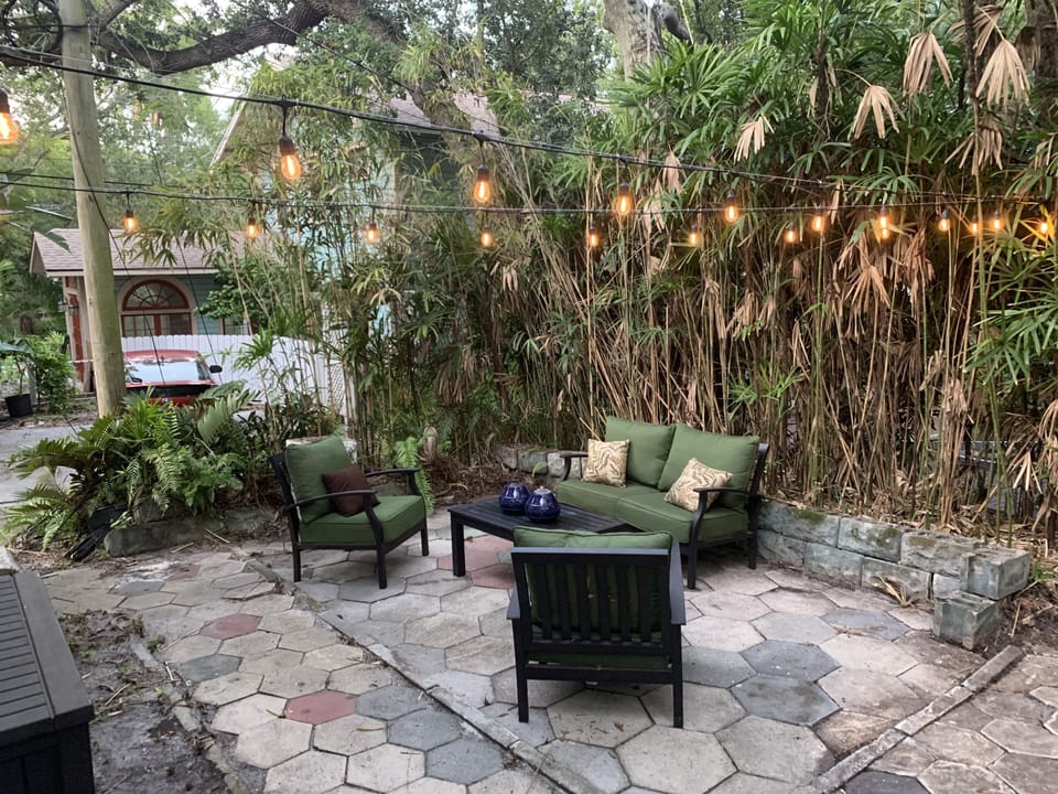Spacious and private patio with outdoor lighting and furniture.