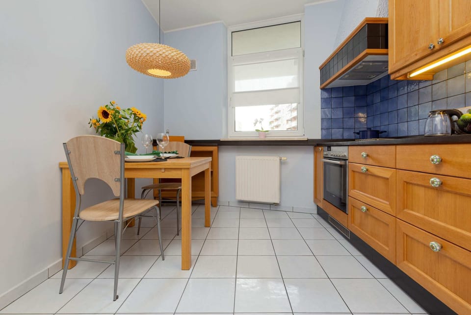 A well-lit dining area adjacent to the kitchen, showcasing a wooden table with chairs and decorative elements like sunflowers.