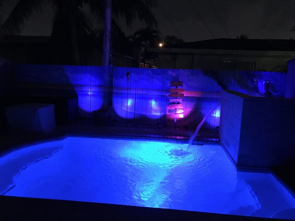 View of pool at night that lights up with waterfall on