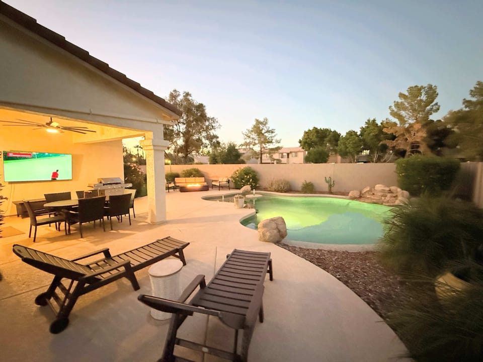 Unwind in your private desert retreat with a heated pool, firepit, and outdoor TV. Perfect for family fun or a golf getaway, this Chandler home offers dining under the patio and stunning Arizona sunset views.