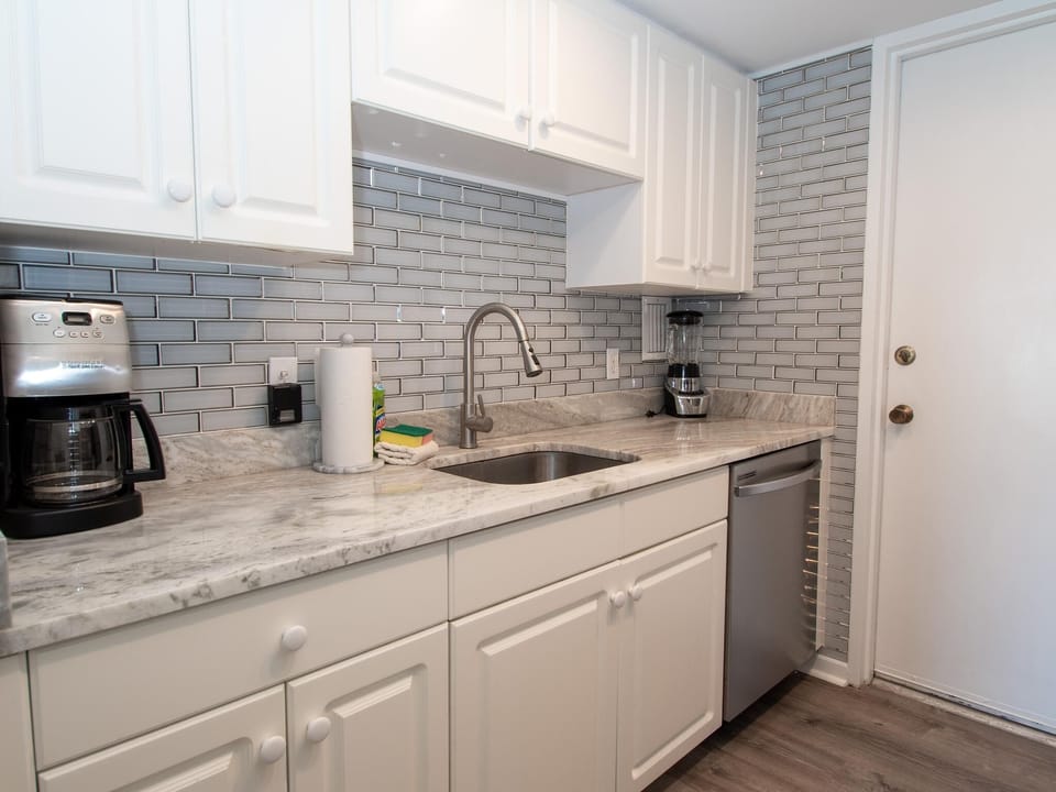 The sleek kitchen is equipped with a modernized coffee maker