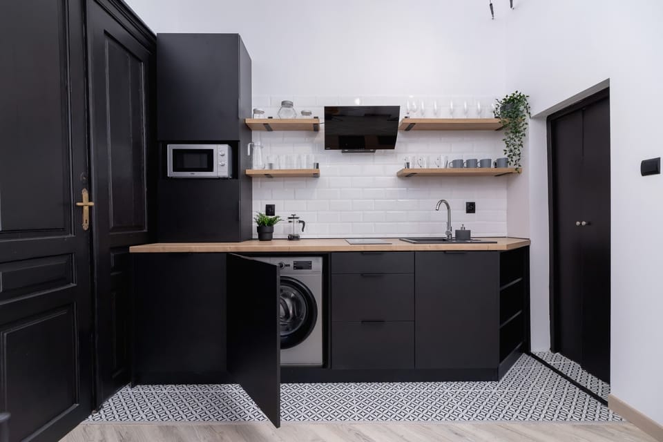 Fully equipped kitchenette with a kettle, fridge with freezer, microwave, coffee machine and washing machine.
