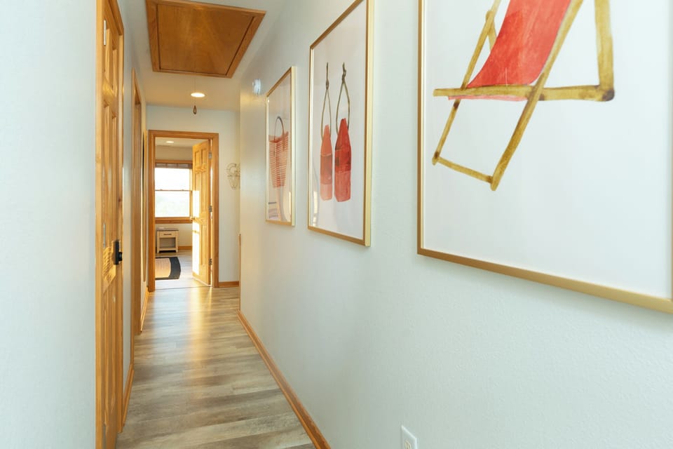 Walk through your welcoming hallway where warm wood accents and curated artwork create an inviting path to your comfortable living spaces.