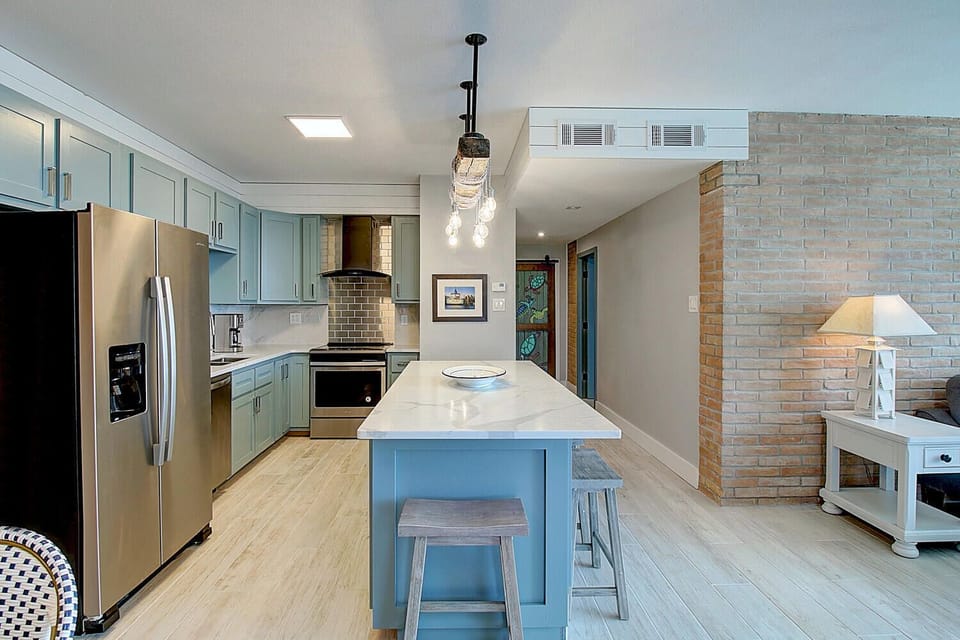 Your spacious kitchen invites culinary adventures with gleaming countertops, stainless steel appliances, and a charming island perfect for morning coffee or evening conversations.