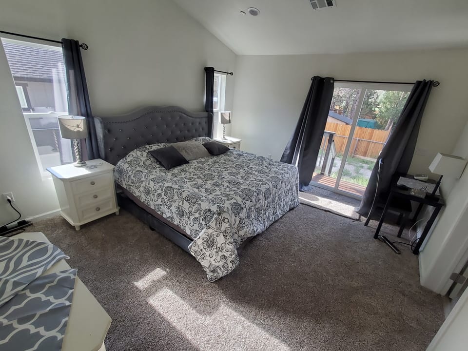 Primary bedroom with king bed, desk, dressers and walk-in closet and ensuite