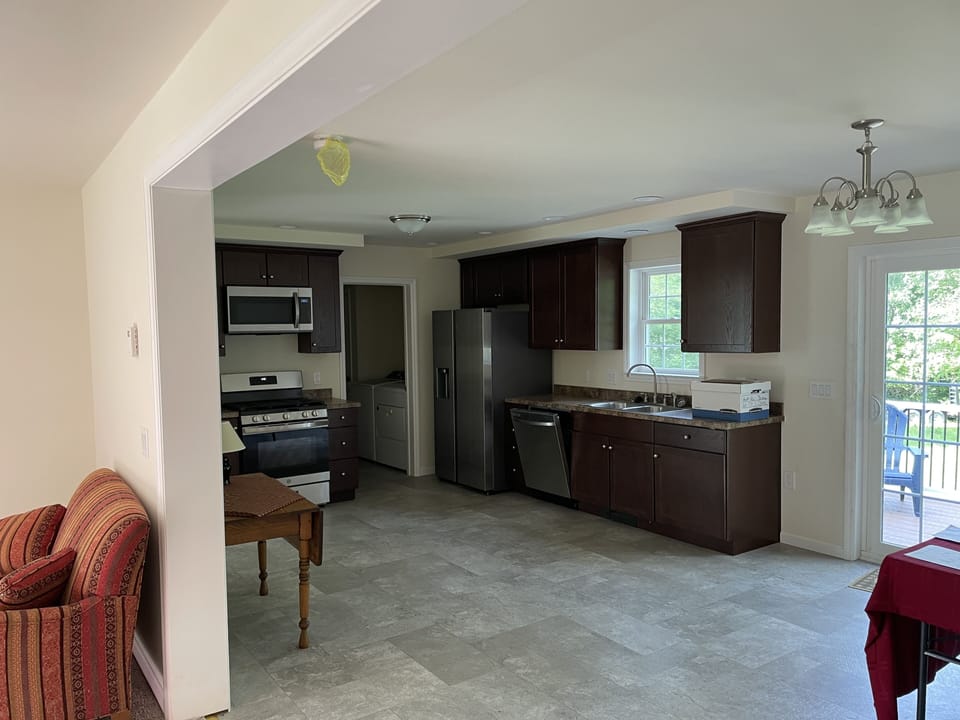 Kitchen with dishwasher, refrigerator gas stove, microwave and laundry area.