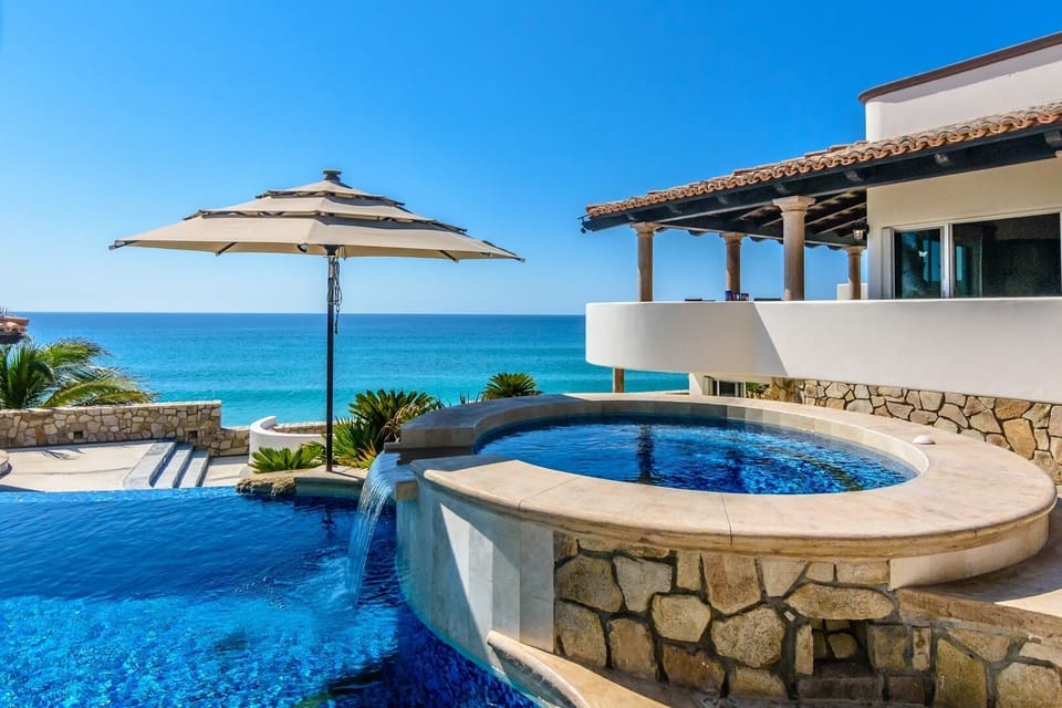 Oceanview hot tub and pool under a shaded palapa with clear skies above