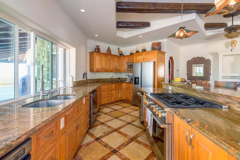 Gourmet kitchen with high-end appliances and rustic tile flooring.