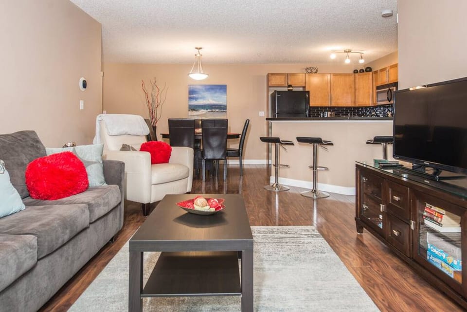 Living room with a TV, DVD player, Playstation 3 and a selection of games, and walkout access to the private balcony.