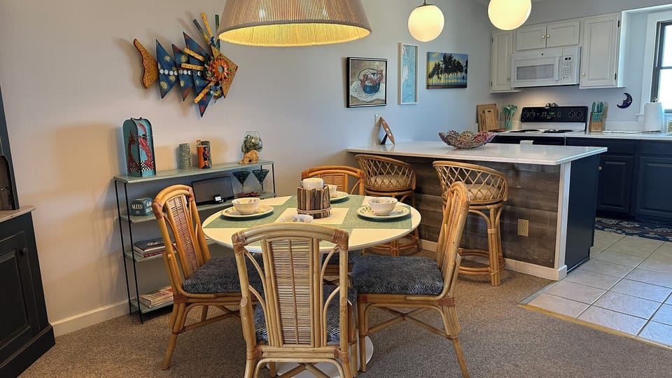 Dining table for four, bar seating for two, and two additional chairs in closet.