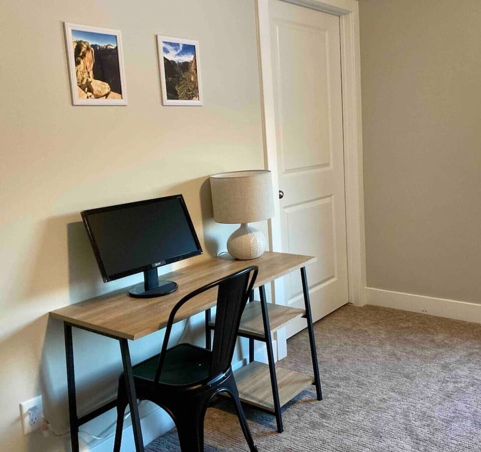 Workspace in the Zion bedroom with a desk, monitor, and HDMI cord