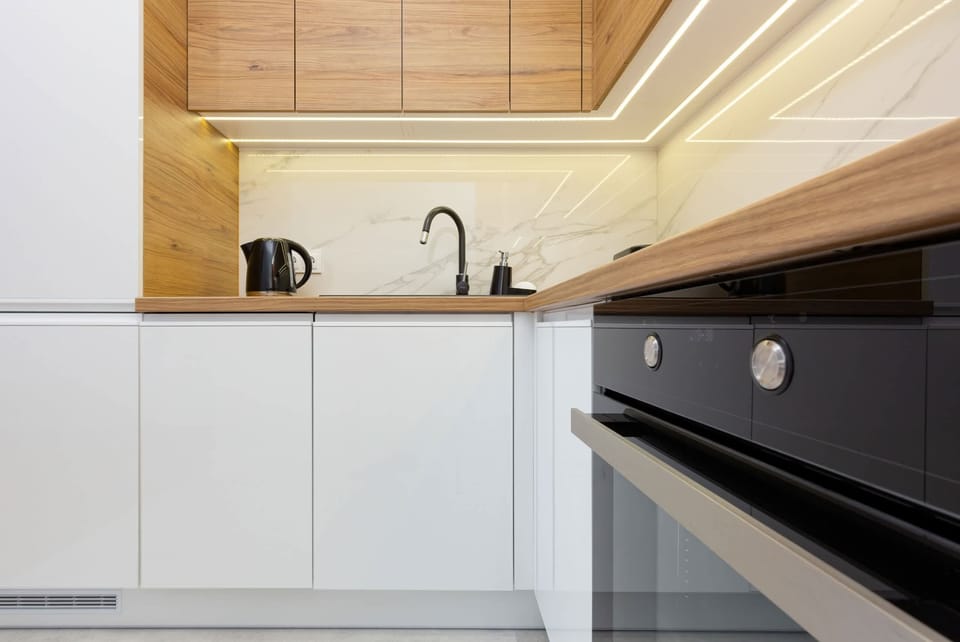 A compact kitchen featuring modern appliances, wooden countertops, and an efficient layout.

