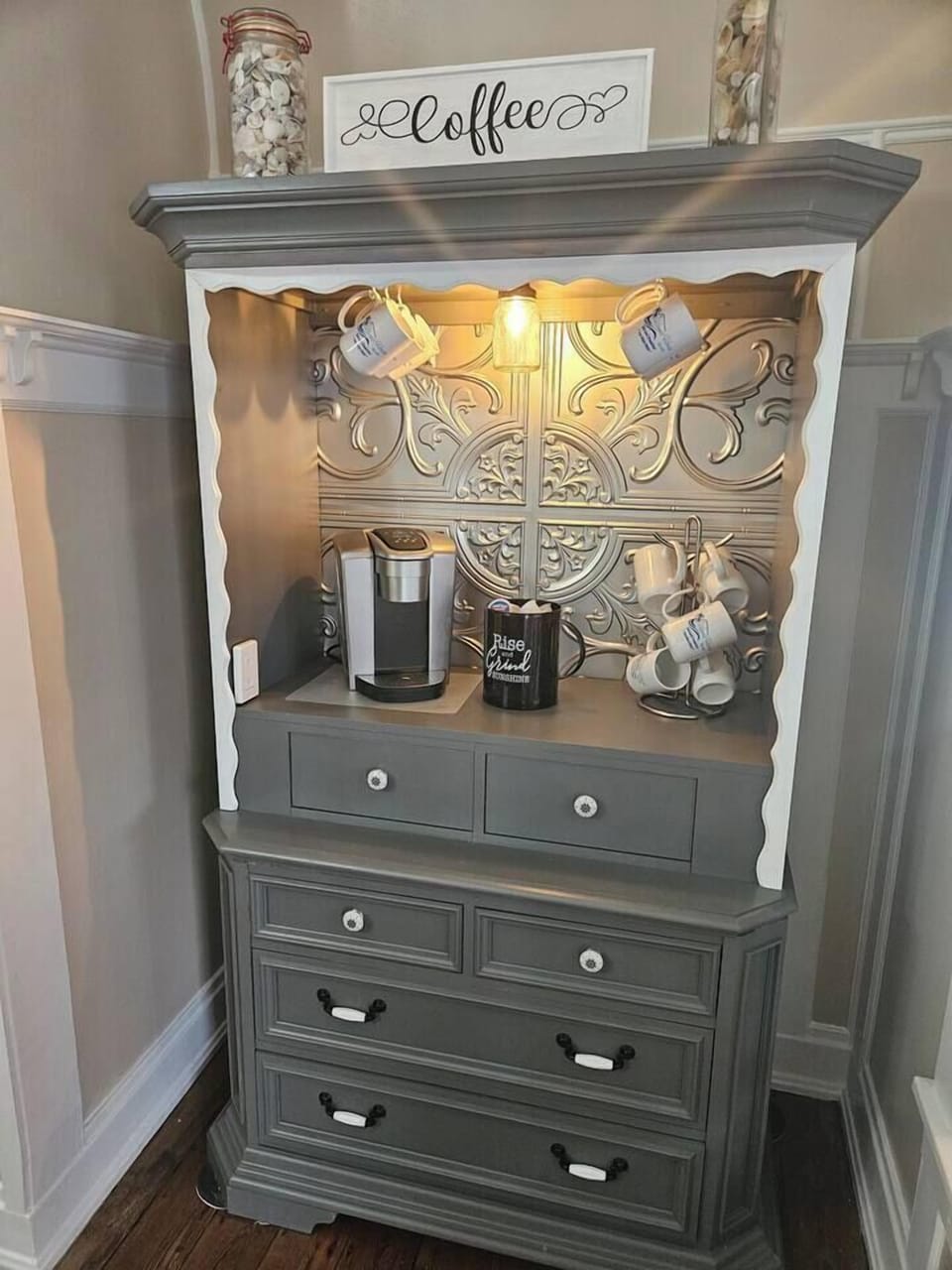 Sip and savor at this charming upcycled coffee bar, complete with a Keurig machine, assorted K‑cups, cream, sugar, and branded coffee mugs.  Everything you need for the perfect cup.