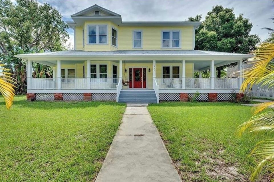 Exterior: Charming yellow facade with inviting porch, perfect for enjoying warm Florida evenings!