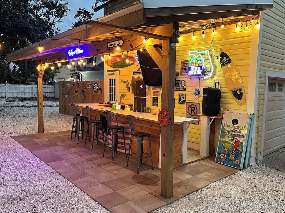 Backyard bar built for entertaining.  Catch the game on a 70" TV, enjoy the glow of outdoor lights, and stream your favorite music on the Bluetooth speaker for the perfect day-to-night hangout.