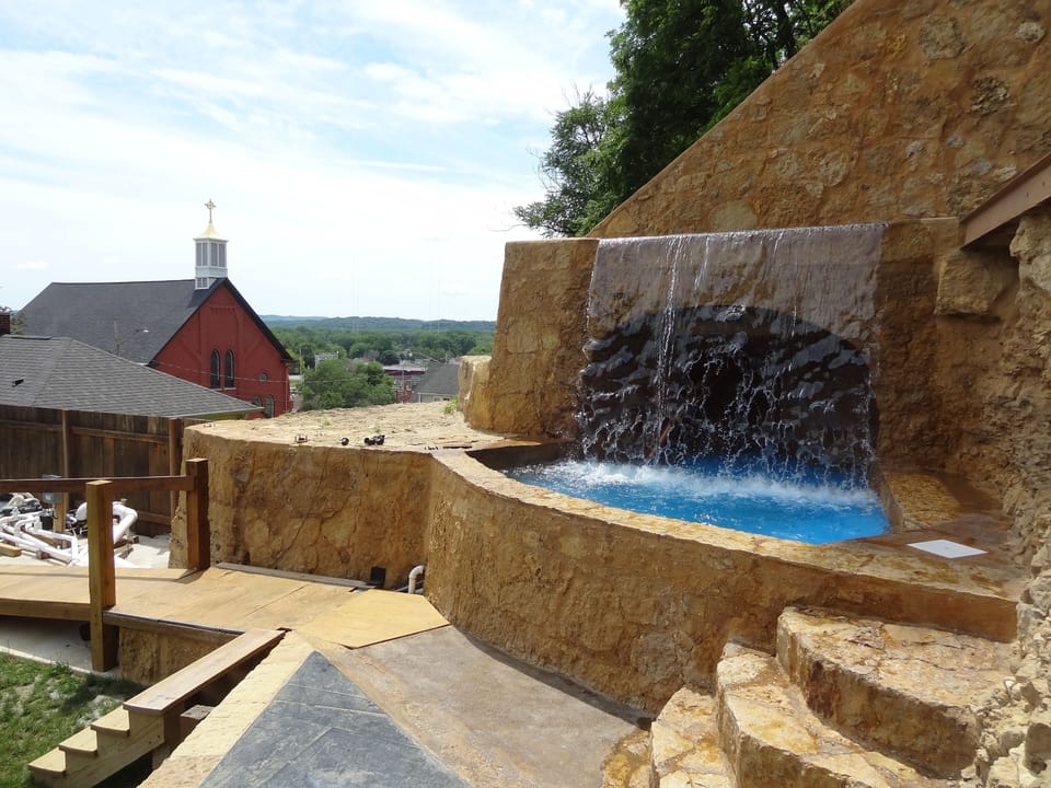 Beautiful ancient castle-like stone work waterfall cave and dipping pond. 