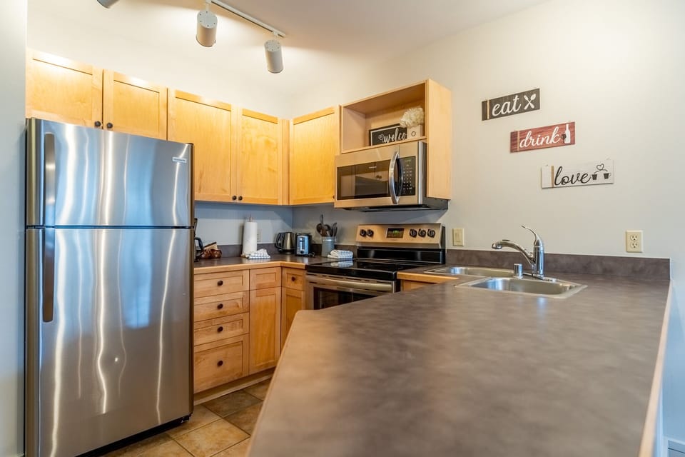 Your fully equipped kitchen awaits with stainless steel appliances, granite countertops, and warm wood cabinets for memorable home-cooked meals.