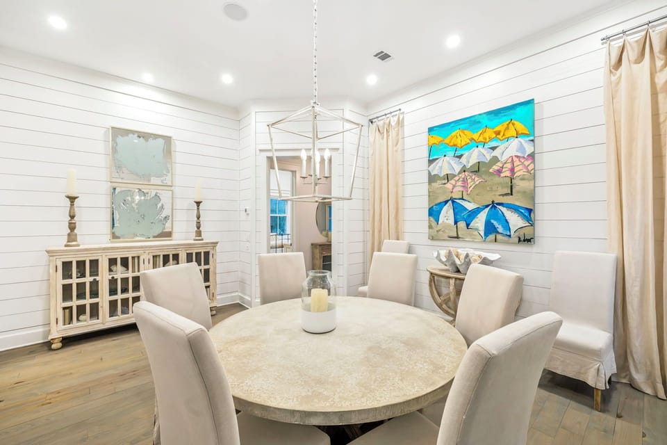 Your elegant dining room features coastal charm with beach umbrella artwork and comfortable seating for memorable meals together.