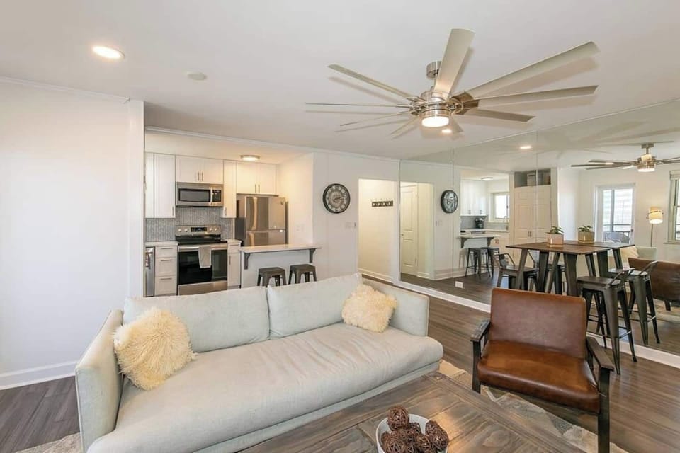 Open-concept living space flowing into a sleek kitchen w/ bar seating & dining nook