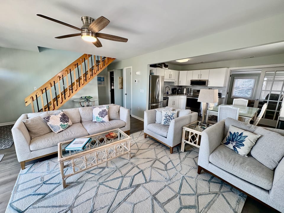 Hallway under the stairs leads to a full bath and 2 bedrooms with queen beds.